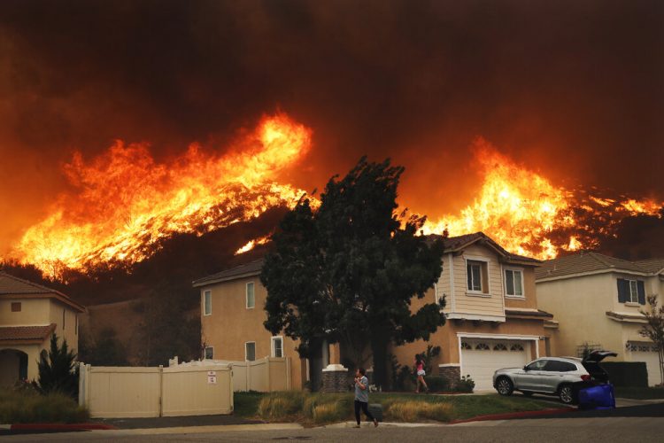 Un incendio forestal se aproxima a un conjunto residencial el 24 de octubre de 2019, en Santa Clarita, California. Foto: Marcio José Sánchez/AP