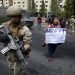 Una mujer protesta junto a un soldado en Santiago de Chile este sábado 19 de octubre. Foto: Esteban Felix/AP.
