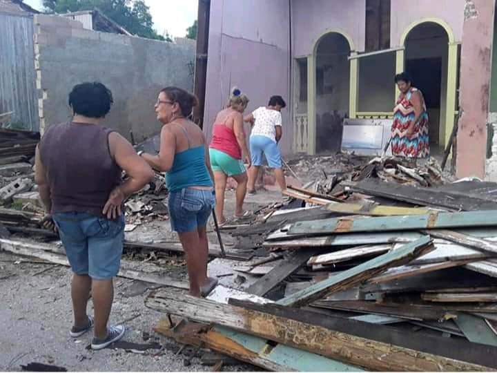 Un grupo de mujeres limpian los escombros tras el derrumbe sufrido por la casa natal del célebre pintor cubano WIfredo Lam, situada en la ciudad de Sagua la Grande, en el centro de Cuba. Foto: Miguel Jiménez / Facebook.