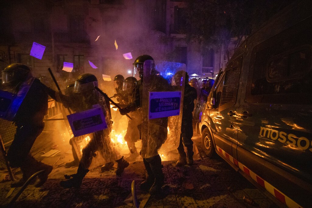 Policías con equipo antimotines pasan por una barricada en llamas durante choques con manifestantes en Barcelona, España, el martes 15 de octubre de 2019. Foto: Emilio Morenatti / AP.