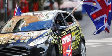 Un hombre ondea una bandera de la Unión Europea y otra británica desde un auto adornado con mensajes contra el Brexit frente a la sede de la UE en Bruselas, el 17 de octubre de 2019. Foto: Frank Augstein/AP