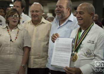 El chef Eddy Fernández (d), presidente de la Federación Culinaria de Cuba, muestra el documento que acredita a la cocina cubana como Patrimonio Cultural de la nación. Junto a él, el ministro de turismo de Cuba, Manuel Marrero (2-d) y Gladys Collazo, presidenta del Consejo Nacional de Patrimonio Cultural (i), entre otras personalidades. Foto: Otmaro Rodríguez.