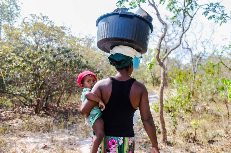 Madre cargando platos sobre la cabeza y su hija a la cintura. Foto: Nicolás Cabrera.