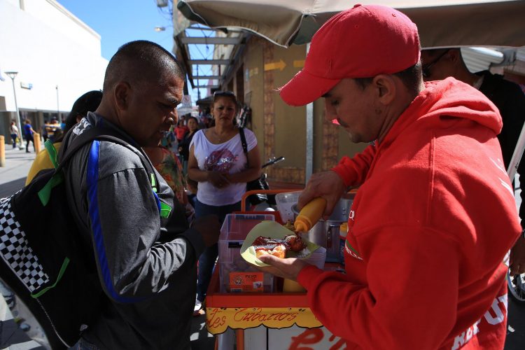 Migrantes cubanos venden sus elotes cubanos en la fronteriza Ciudad Juárez, México. Foto: Luis Torres / EFE.