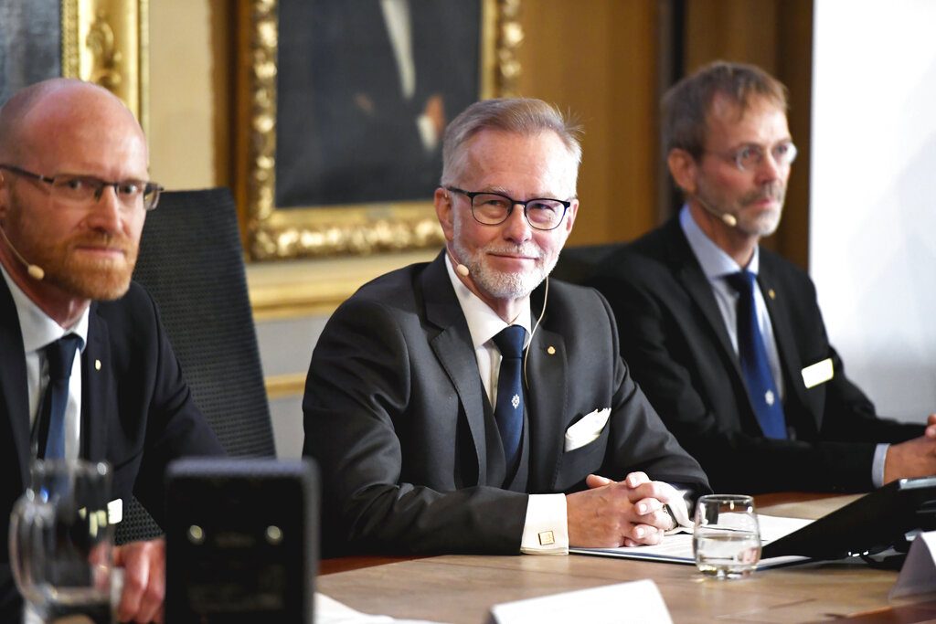 El secretario general de la Academia Sueca de Ciencias, Goran K Hansson, en el centro, y los académicos Peter Fredriksson, a la izquierda, y Jakob Svensson anuncian los ganadores del Nobel de Economía durante una rueda de prensa en la Academia Sueca de Ciencias en Estocolmo, Suecia, el lunes 14 de octubre de 2019. Foto AP