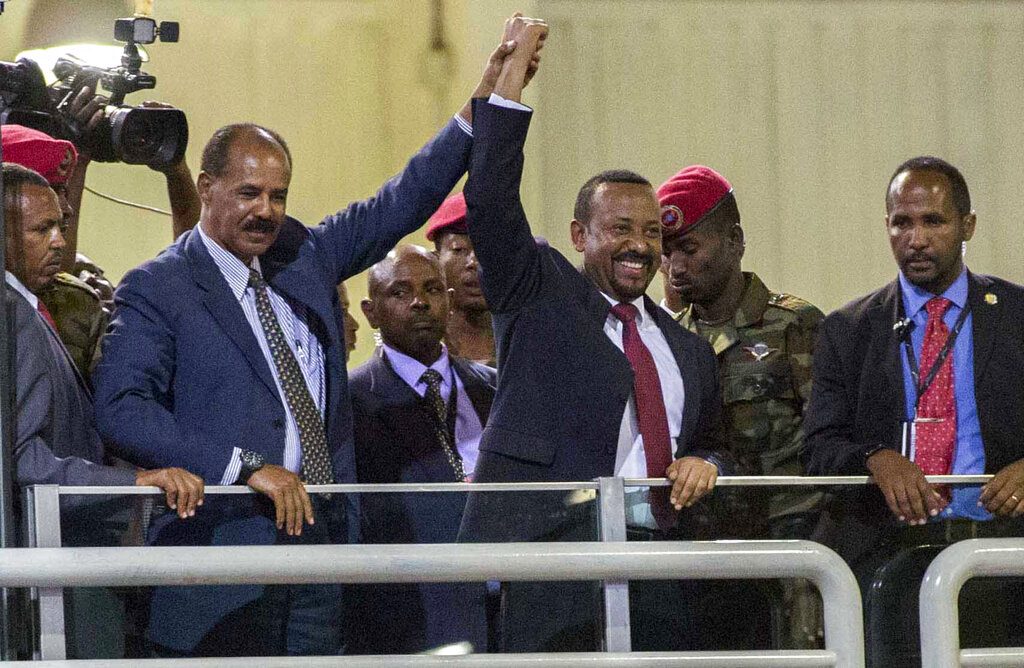 En esta fotografía de archivo del domingo 15 de julio de 2018, el presidente eritreo Isaias Afwerki, segundo de izquierda a derecha, y el premier etíope Abiy Ahmed, al centro, sostienen las manos en alto ante una multitud en Adis Abeba, Etiopía. A Ahmed le fue otorgado el premio Nobel de la Paz el viernes 11 de octubre de 2019. Foto: Mulugeta Ayene/AP/Archivo.