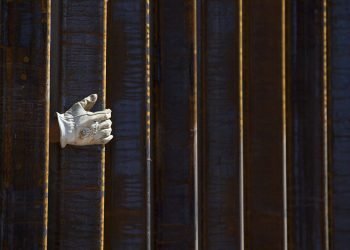 La mano de un albañil se asoma por una parte del muro fronterizo en construcción en Lukeville, Arizona, el 8 de octubre de 2019. Foto: AP