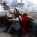 Manifestantes a favor del expresidente boliviano Evo Morales se protegen de las nubes de gas lacrimógeno lanzado por la policía, en La Paz, Bolivia, el 15 de noviembre de 2019. (AP Foto/Natacha Pisarenko)