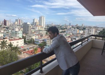 Ernesto Blanco observa la ciudad desde el balcón de la sede de OnCuba. Foto: Michel Hernández