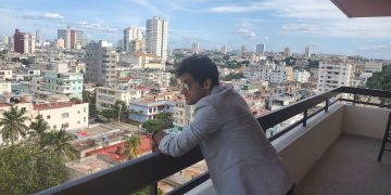 Ernesto Blanco observa la ciudad desde el balcón de la sede de OnCuba. Foto: Michel Hernández