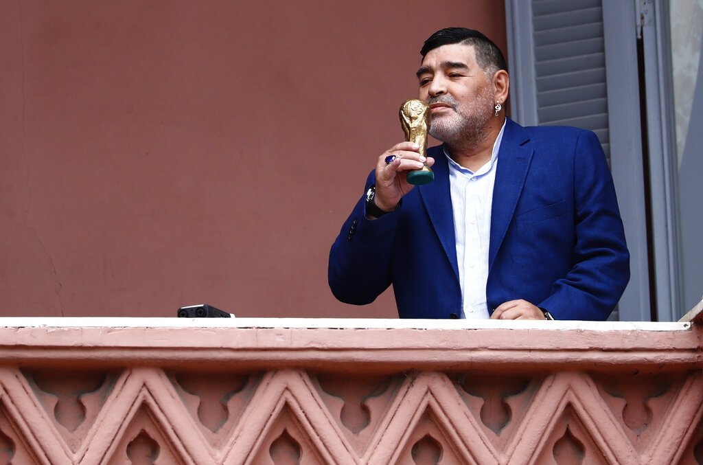 Diego Maradona sostiene una pequeña réplica de la Copa Mundial de la FIFA mientras la besa frente a los fanáticos en la casa del gobierno después de su reunión con el presidente argentino Alberto Fernández en Buenos Aires, Argentina, el jueves 26 de diciembre de 2019. Foto: AP/Marcos Brindicci
