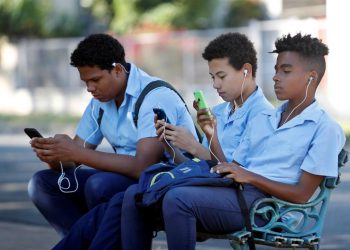 Un grupo de estudiantes usa su teléfono celular en un parque de La Habana. EFE/ Yander Zamora