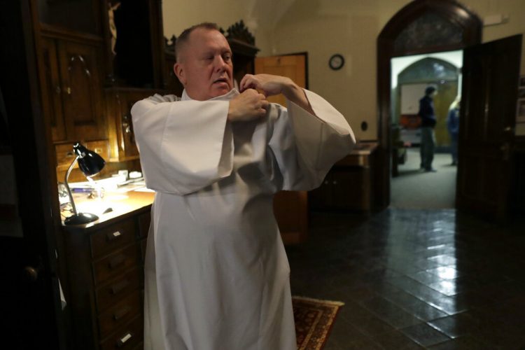 El reverendo Mark Stelzer se prepara para oficiar una misa en la iglesia de San Gerónimo en Holyoke, Massachusetts, el 9 de noviembre del 2019. Foto: Steven Senne / AP.