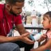 El médico cubano Dairon Elisondo trata a una niña de 4 años, enferma de asma, en un campamento de migrantes en Matamoros, México. Foto: Ilana Panich-Linsman / The New York Times.