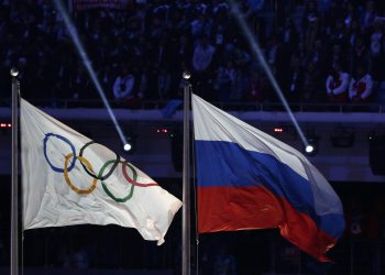 La bandera rusa ondea junto a la bandera olímpica durante la ceremonia de clausura de los Juegos Olímpicos de Invierno de 2014 en Sochi, Rusia.  Esta acusó al principal testigo de la Agencia Mundial Antidopaje (AMA) de modificar importantes datos de laboratorio. Foto: Matthias Schrader/AP.