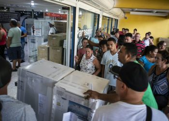 Personas a la entrada de una tienda para la venta en moneda libremente convertible de equipos electrodomésticos en La Habana. Foto: AP / Archivo.