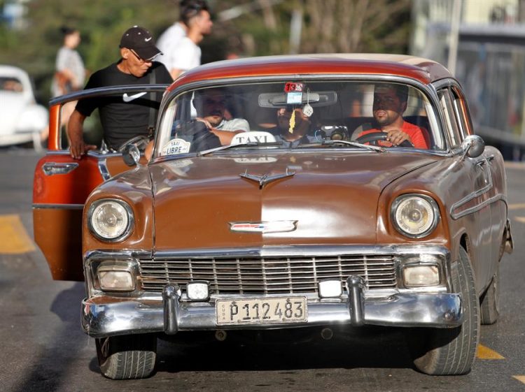 Un grupo de personas suben a un automóvil clásico que funciona como taxi en La Habana (Cuba). Foto: EFE/ Yander Zamora