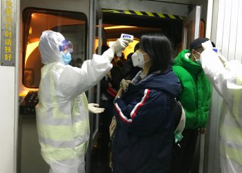 Funcionarios de salud revisan la temperatura corporal de los pasajeros que llegan de la ciudad de Wuhan al aeropuerto de Beijing, el miércoles 22 de enero de 2020. Foto: AP/Emily Wang