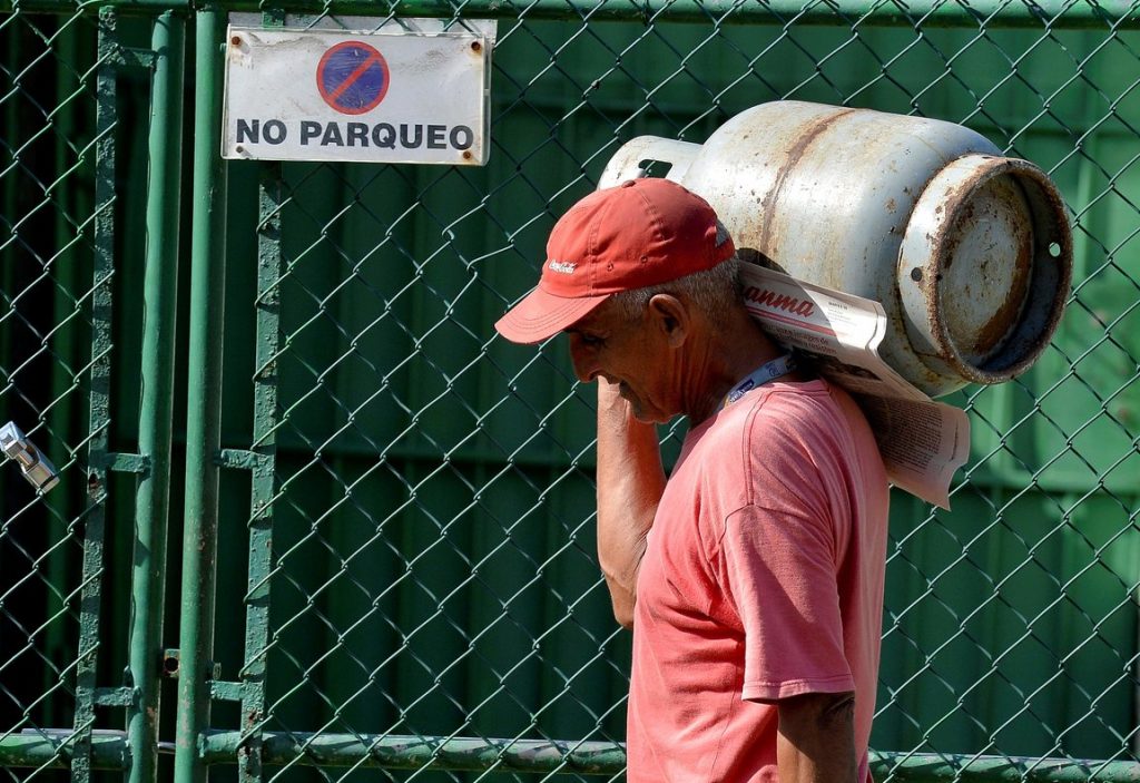 Un hombre carga un cilindro o balita de gas licuado en Cuba. Foto: AFP / Archivo.