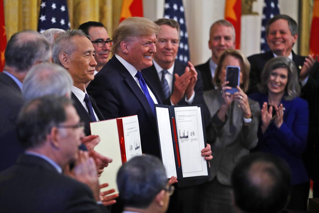 El presidente Donald Trump, centro, y el viceprimer ministro chino Liu He, izquierda, sostienen el acuerdo comercial después de haberlo firmado en la Sala Este de la Casa Blanca, el miércoles 15 de enero de 2020 en Washington. Foto: AP/Steve Helber