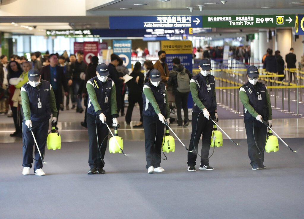 Empleados rocían una solución antiséptica en el lobby de llegada al aumentar las preocupaciones sobre la posible propagación del nuevo coronavirus en el aeropuerto internacional en Incheon, Corea del Sur, el martes 21 de enero de 2020. Foto: Suh Myung-geon/Yonhap vía AP