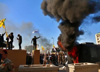 Manifestantes encienden una pira enfrente de la embajada de Estados Unidos en Bagdad, Irak, el martes 31 de diciembre de 2019. (AP Foto/Khalid Mohammed)