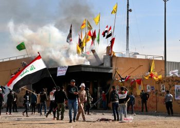 Milicianos proiraníes y sus partidarios provocan un incendio mientras soldados estadounidenses lanzan gases lacrimógenos en la embajada de Estados Unidos en Bagdad el 1 de enero de 2020. Foto: Khalid Mohammed/AP.