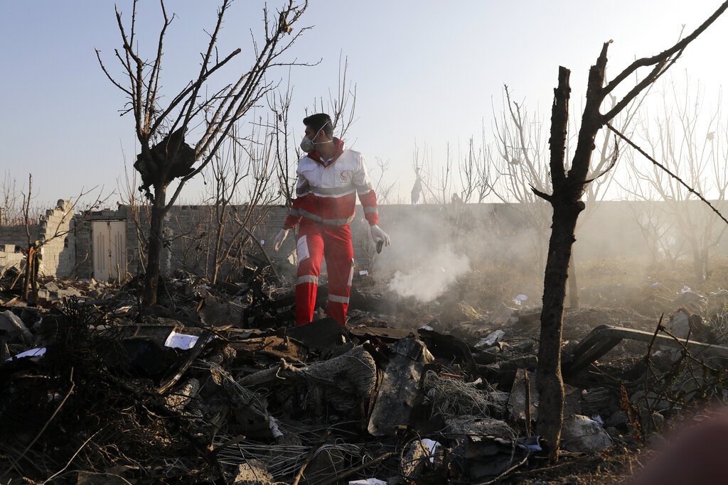 Un rescatistas busca entre los escombros en el lugar donde se estrelló un avión de pasajeros ucraniano, en Shahedshahr, al suroeste de Teherán, Irán, el 8 de enero de 2020. Foto: AP/Ebrahim Noroozi