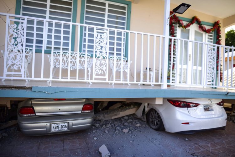 Una vivienda cayó sobre vehículos estacionados después de un terremoto registrado en Guánica, Puerto Rico, el lunes 6 de enero de 2020. Un sismo de magnitud 5,8 remeció Puerto Rico en la madrugada del lunes, provocando pequeños deslaves, cortes en el suministro eléctrico y graves grietas en algunas viviendas. (AP Foto/Carlos Giusti)