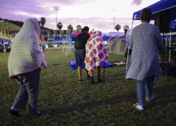 Varias personas se ponen de pie luego de pasar la noche en un estadio de béisbol tras un sismo de magnitud 6,4 en Guayanilla, Puerto Rico, el viernes 10 de enero de 2020. Foto: AP/Carlos Giusti