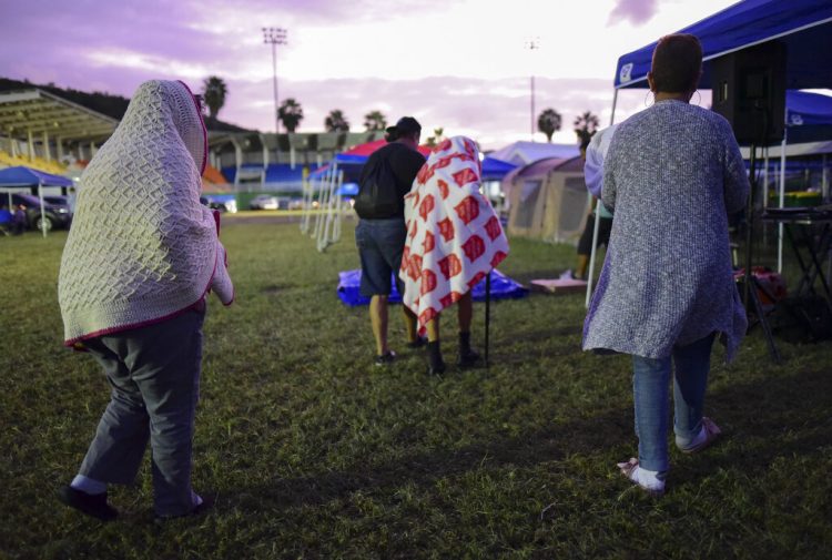 Varias personas se ponen de pie luego de pasar la noche en un estadio de béisbol tras un sismo de magnitud 6,4 en Guayanilla, Puerto Rico, el viernes 10 de enero de 2020. Foto: AP/Carlos Giusti