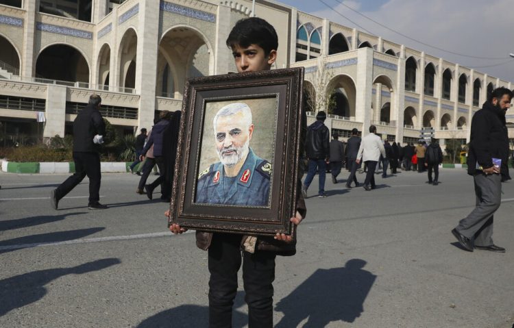 Un niño carga un retrato del general iraní Qassem Soleimani, quien murió en un ataque perpetrado por Estados Unidos en Irak, el viernes 3 de enero de 2020 en Teherán, Irán. (AP Foto/Vahid Salemi)
