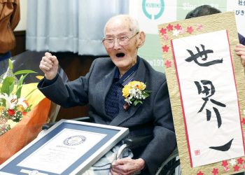 Chitetsu Watanabe, de 112 años, posa junto a un cartel que escribió tras ser condecorado como el hombre más viejo del mundo por el Guinness World Records. (Kyodo News via AP)