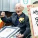 Chitetsu Watanabe, de 112 años, posa junto a un cartel que escribió tras ser condecorado como el hombre más viejo del mundo por el Guinness World Records. (Kyodo News via AP)
