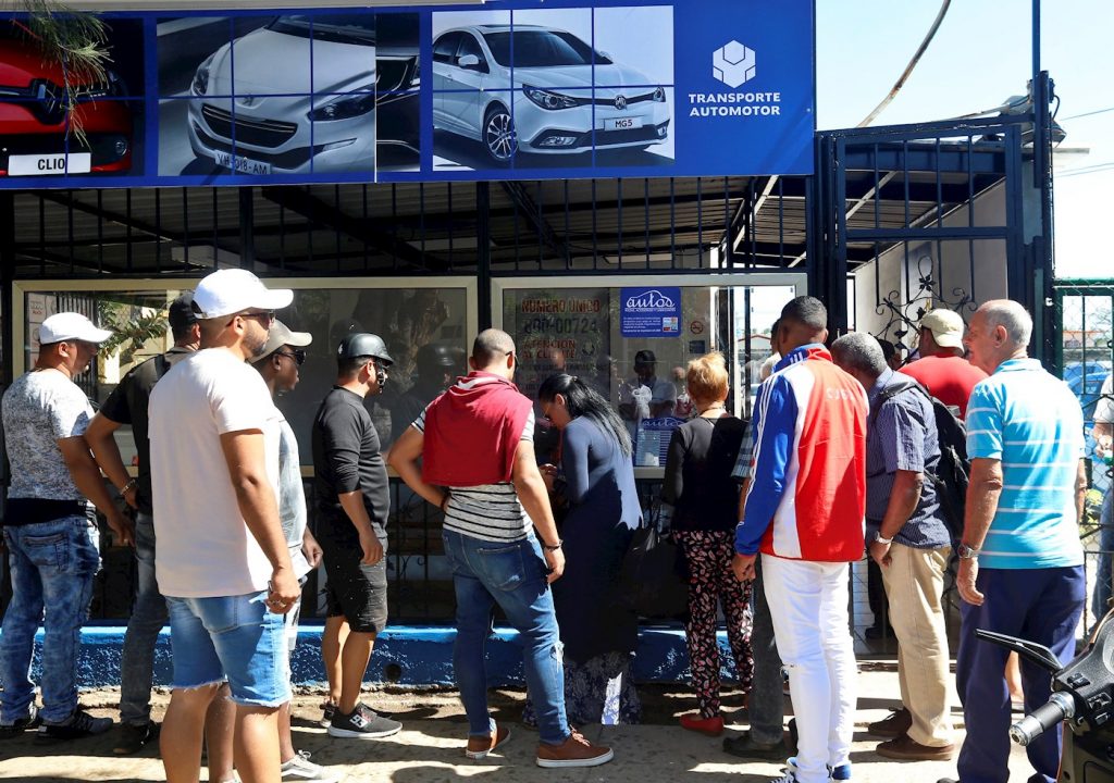 Varias personas hacen fila para la compra de autos de segunda mano en La Habana, cuya venta en moneda libremente convertible por parte del gobierno cubano comenzó el martes 25 de febrero de 2020. Foto: Ernesto Mastrascusa / EFE.