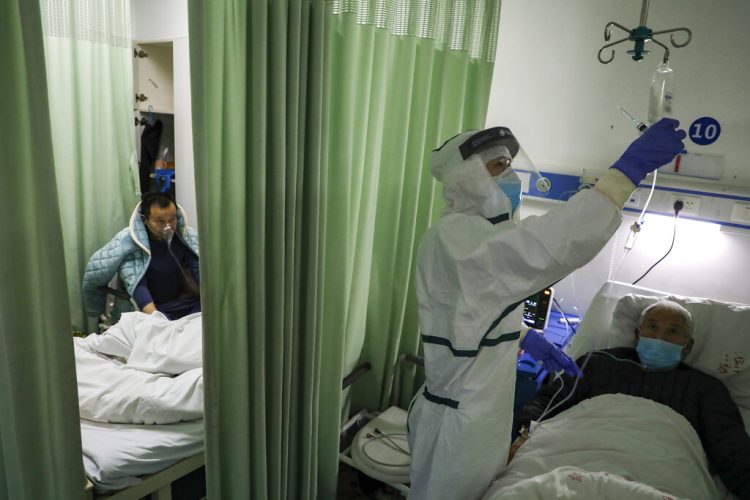 Una enfermera comprueba el estado de un paciente en un ala de aislamiento para pacientes del coronavirus 2019-nCoV en un hospital de Wuhan, en la provincia china de Hubei. Foto: Chinatopix vía AP.