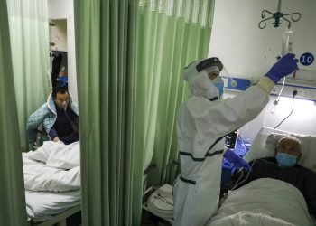 Una enfermera comprueba el estado de un paciente en un ala de aislamiento para pacientes del 2019-nCoV en un hospital de Wuhan, en la provincia china de Hubei. Foto: Chinatopix via AP.