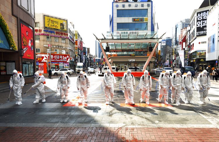Soldados surcoreanos con vestimenta protectora rocían desinfectante para impedir la propagación del virus del COVI-19 en una calle en Dargu. Corea del Sur, jueves 27 de febrero de 2020. Foto: Lee Moo-ryul/Newsis vía AP.