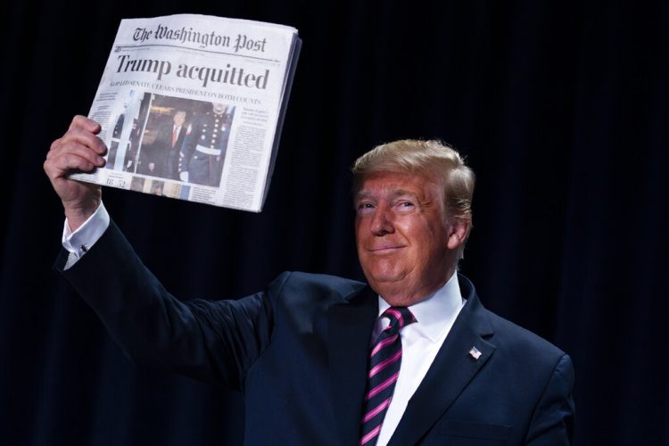 El presidente Donald Trump alza un diario con el titular "Trump absuelto" durante el 68vo Desayuno Nacional de Oración en Washington, jueves 6 de enero de 2020. (AP Foto/ Evan Vucci)