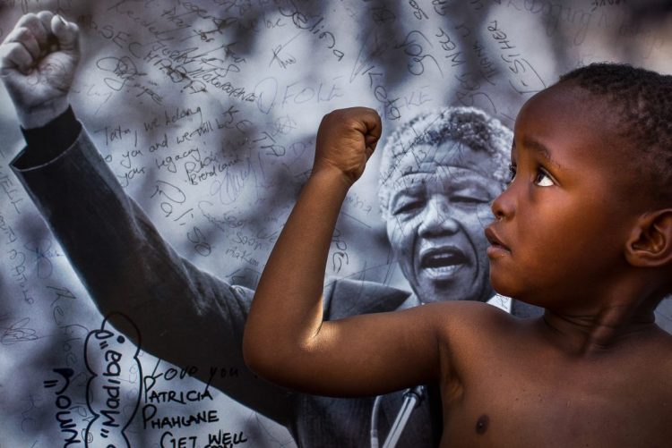 Un niño imita el gesto de Nelson Mandela en Pretoria, Sudáfrica, en en 2013. Foto: Ben Curtis/AP.