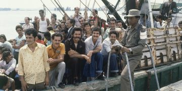 Un soldado cubano custodia un barco  en el puerto de Mariel el 23 de abril de 1980, mientras las personas a bordo esperan para navegar hacia Estados Unidos. Foto: Jacque Langevin/AP.