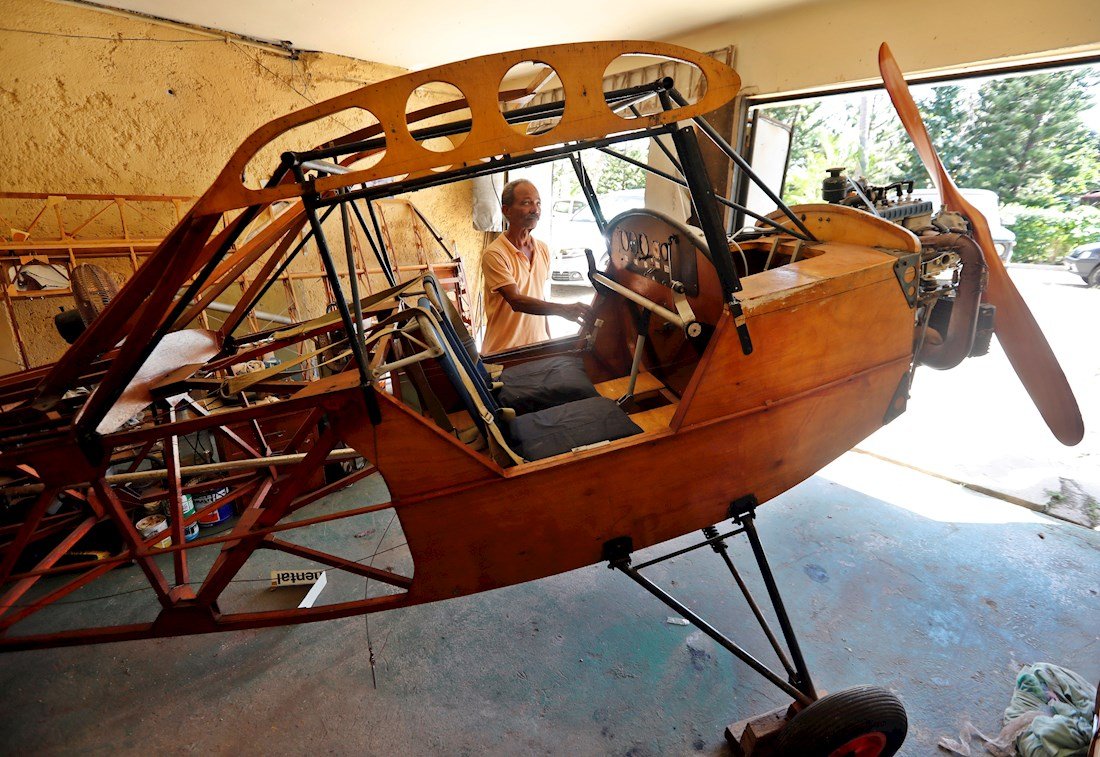 Fotografía fechada el 19 de febrero de 2020, que muestra a Adolfo Rivera, ingeniero y mecánico en Cuba, mientras revisa partes de su avión, en La Habana. Foto: EFE/ Ernesto Mastrascusa