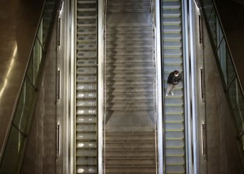 Un hombre sobre la escalera eléctrica de una estación de tren vacía en Barcelona. Foto: Joan Mateu/AP.