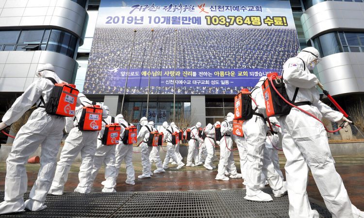 En esta foto del 1 de marzo del 2020,  soldados sudcoreanos con trajes protectores fumigan desinfectante para prevenir la diseminación del coronavirus en la ciudad de Daegu.  (Lee Moo-ryul/Newsis via AP)