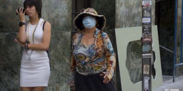 Una mujer se cubre parte del rostro con una mascarilla en La Habana, el 12 de marzo de 2020, luego de que las autoridades sanitarias informaran sobre casos de enfermos con Covid-19 en la Isla. Foto: Otmaro Rodríguez.