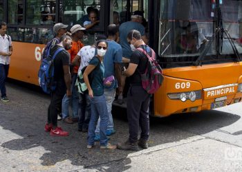 Personas se cubre parte del rostro con una mascarilla antes de subir a un ómnibus en La Habana, luego de que las autoridades sanitarias informaran sobre casos de enfermos con Covid-19 en la Isla. Foto: Otmaro Rodríguez.
