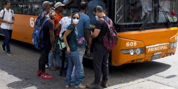 Personas se cubre parte del rostro con una mascarilla antes de subir a un ómnibus en La Habana, luego de que las autoridades sanitarias informaran sobre casos de enfermos con Covid-19 en la Isla. Foto: Otmaro Rodríguez.