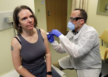 Un farmacéutico aplica a Jennifer Haller la primera dosis de una prueba clínica para una posible vacuna contra el COVID-19, la enfermedad causada por el nuevo coronavirus, el lunes 16 de marzo de 2020, en el Instituto de Investigación Permanente Kaiser de Washington en Seattle. Foto: AP/Ted S. Warren.