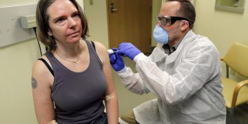 Un farmacéutico aplica a Jennifer Haller la primera dosis de una prueba clínica para una posible vacuna contra el COVID-19, la enfermedad causada por el nuevo coronavirus, el lunes 16 de marzo de 2020, en el Instituto de Investigación Permanente Kaiser de Washington en Seattle. Foto: AP/Ted S. Warren.