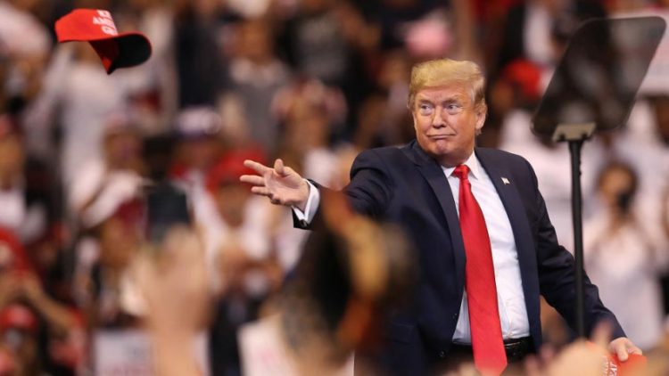 Donald Trump, arroja una gorra de su campaña durante un mítin de campaña en noviembre de 2019 en Sunrise, Florida. Foto: Joe Raedle / Getty Images.